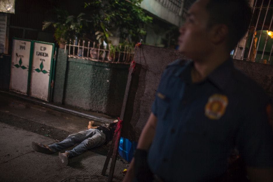 A suspected drug user lies dead on the ground in Tondo, Manila. Witnesses say he was shot in the face by masked men.